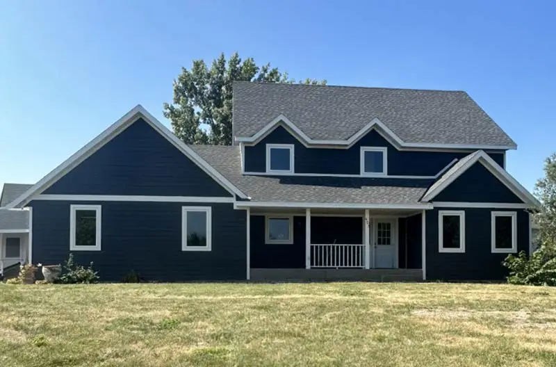 An after photo of A newly roofed two-story house with a navy blue exterior and white trim. Renovated by Refresh Exteriors LLC Minnesota’s most referred roofing contractor