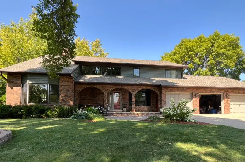 An after photo of A newly roofed two-story house with a navy blue exterior and white trim. Renovated by Refresh Exteriors LLC Minnesota’s most referred roofing contractor