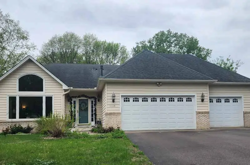 The "Before" images of a two-story house with beige siding, a dark gray roof showing signs of wear, and a three-car garage. The house could benefit from exterior updates