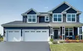 A newly roofed two-story house with a navy blue exterior and white trim. Renovated by Refresh Exteriors LLC Minnesota’s most referred roofing contractor